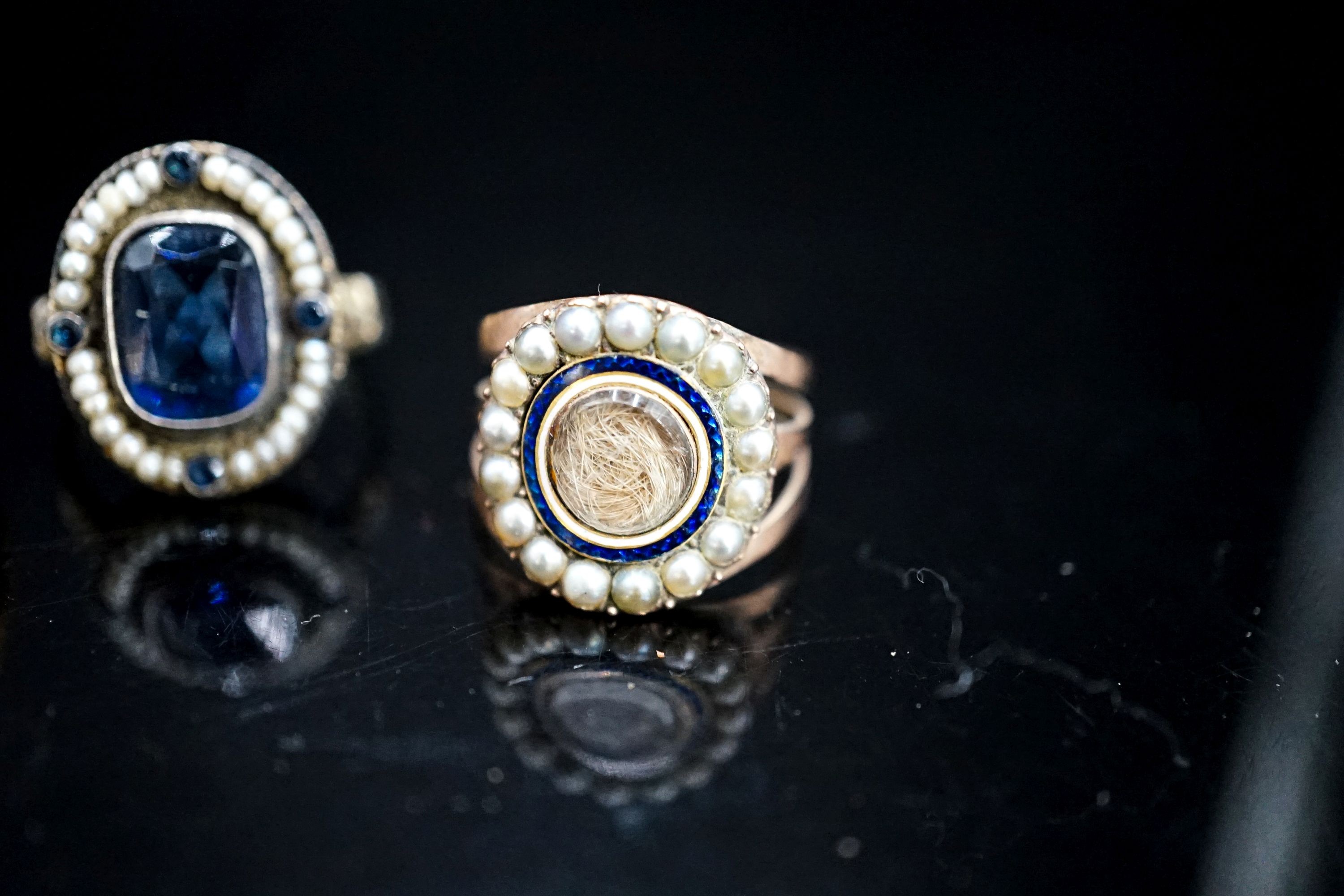 A 19th century yellow metal, two colour enamel and seed pearl set mourning ring, with hair beneath a glazed panel, size N, a 19th century Austro-Hungarian white metal and blue paste ring and a later 9ct gold signet ring(